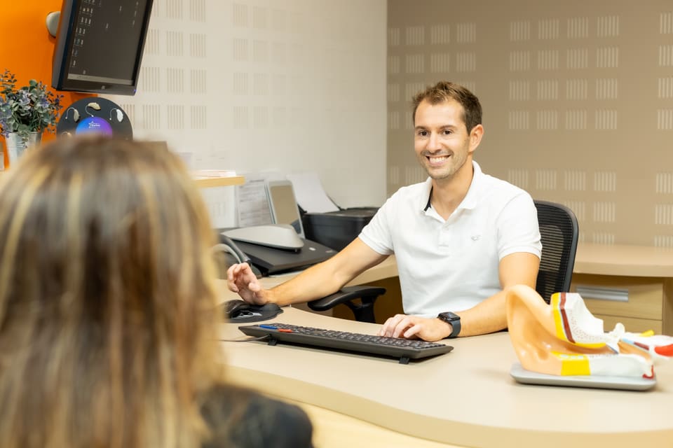 Une collaboratrice accueillant une cliente et son enfant.