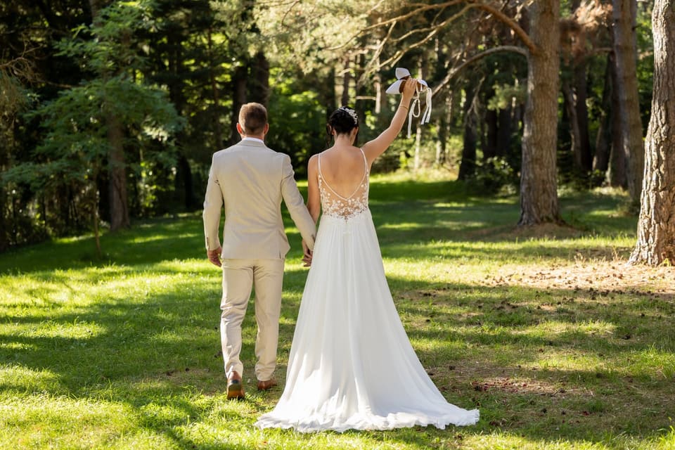 Une main de mariée portant son alliance, posée sur la dentelle